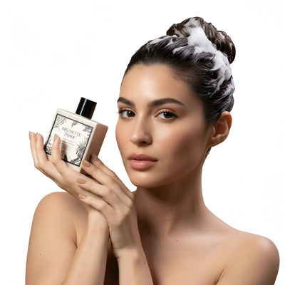 Una bottiglia elegante e rettangolare di shampoo per capelli castani con tappo nero e design di etichetta botanica raffinata.