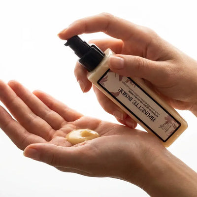 Una bottiglia a pompa beige con un dispensatore nero e un'etichetta con illustrazioni botaniche, etichettata ’bainette inside’ by kordé.