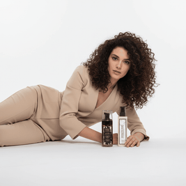 Donna con capelli ricci castani e sorriso luminoso che emana Curly Vibes