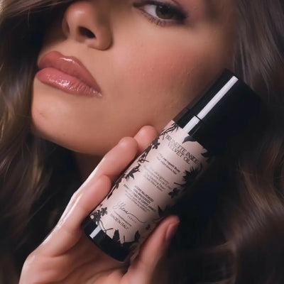 Una elegante bottiglia nera e bianca di brunet dentro olio di velluto con finitura opaca, adornata con raffinate illustrazioni botaniche sulla sua etichetta.