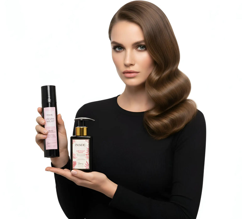 Flacone spray cilindrico nero con etichetta rosa e dispenser a pompa dorato