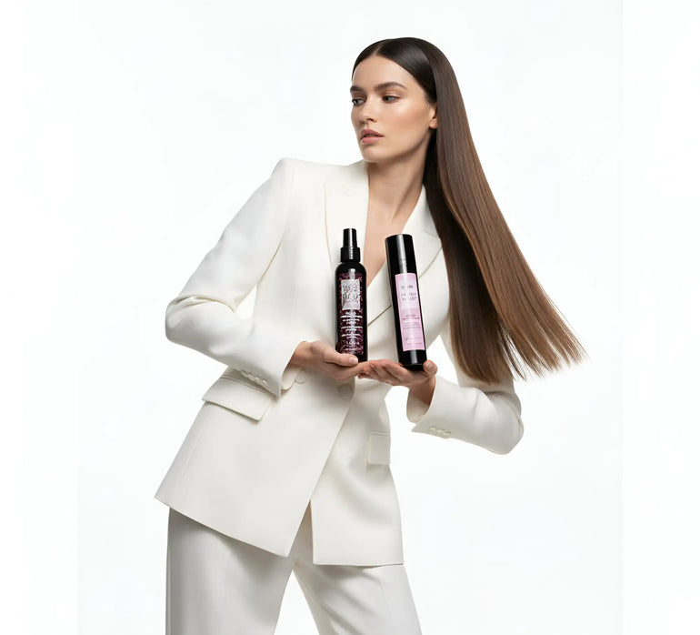 Flaconi spray neri con etichette rosa tenuti nelle mani di una donna