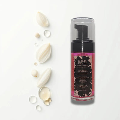 Una maschera capillare schiumosa rosa in una bottiglia di vetro trasparente con pompa nera, etichettata ’blonde inside pink cloud’ di ykena beauty.